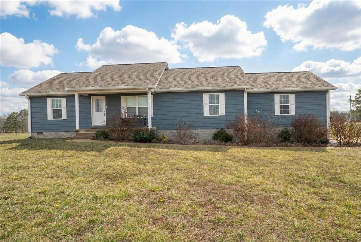 a front view of house with yard and trees around
