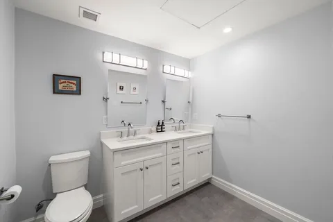 a spacious bathroom with a toilet sink and mirror