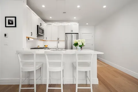 a kitchen with kitchen island cabinets and chairs in it