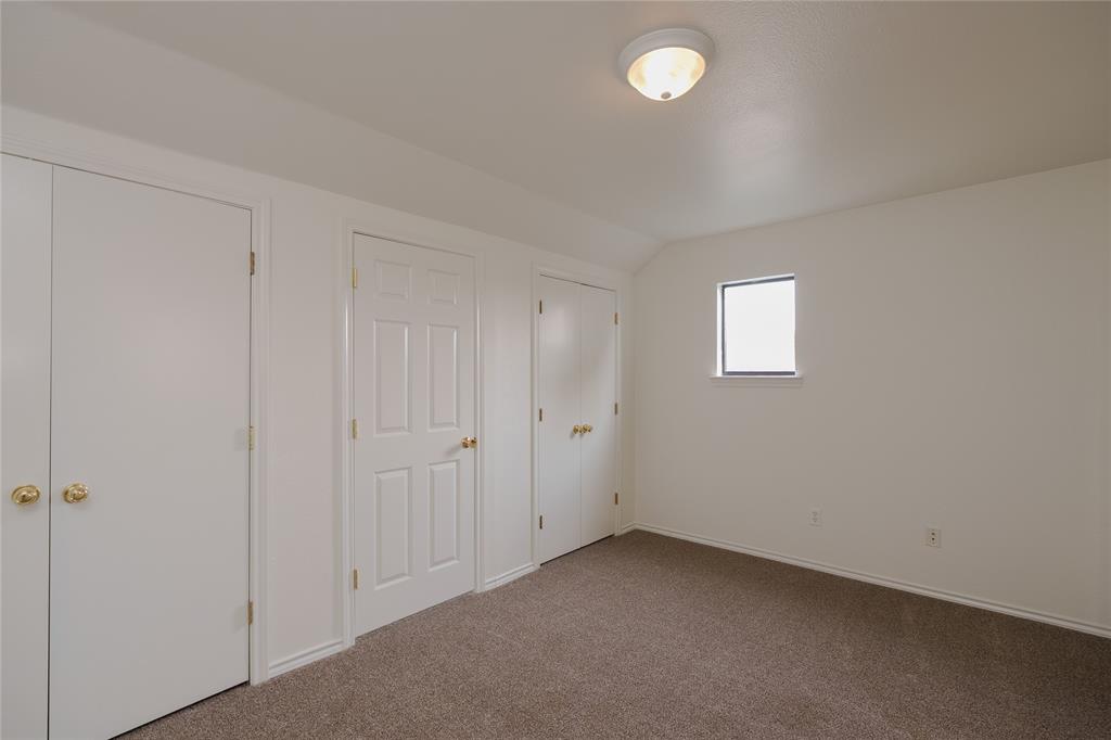 364 Parker Road, Unit A Van Alstyne, TX 75495 - Photo 33 of 39 Carpeted interior space featuring multiple white panel doors with brass hardware, a single window, and a flush-mount ceiling light fixture