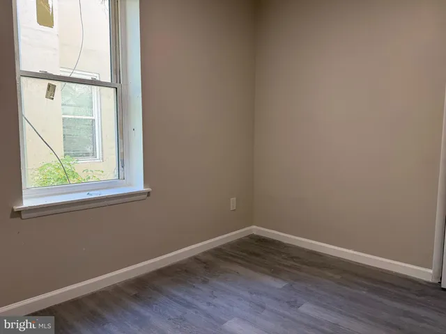 a view of a small space with wooden floor and a window