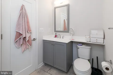a bathroom with a sink vanity mirror and toilet