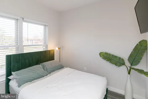 a bedroom with a bed mirror and a window