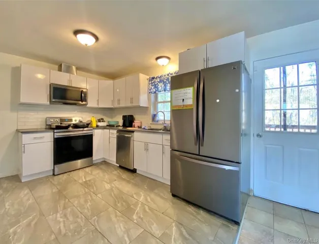 a kitchen with granite countertop a refrigerator and a stove top oven