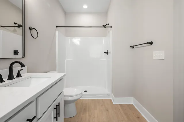 a bathroom with a sink a toilet and shower