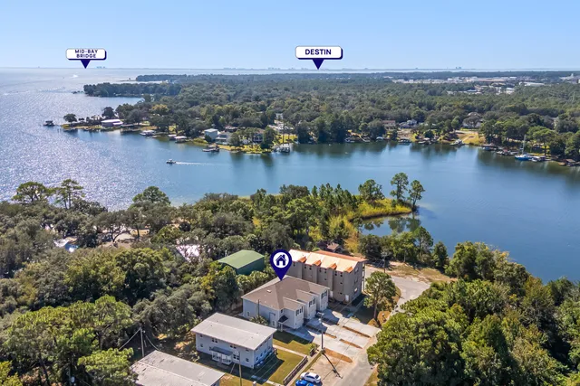 an aerial view of residential houses with outdoor space and lake view