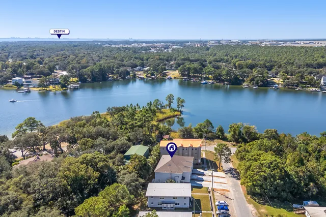 an aerial view of residential houses with outdoor space and lake view