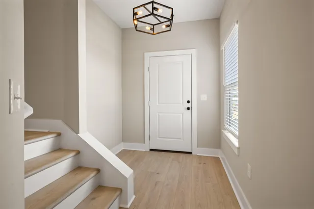 a view of a hallway with wooden floor and staircase