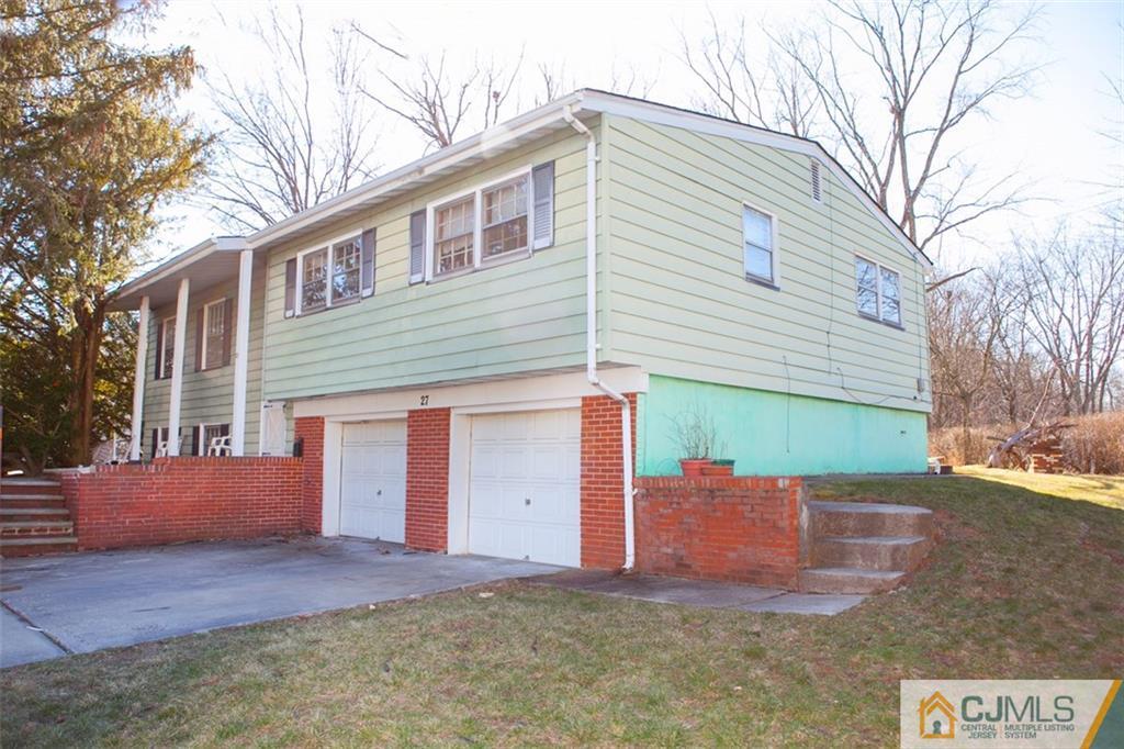 27 Wilk Road Edison, NJ 08837 - Photo 1 of 1 a front view of a house with a yard and garage