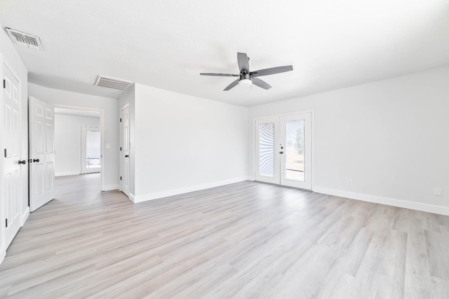 16680 Austin Street Madera, CA 93638 - Photo 13 of 40 a view of empty room with wooden floor and ceiling fan