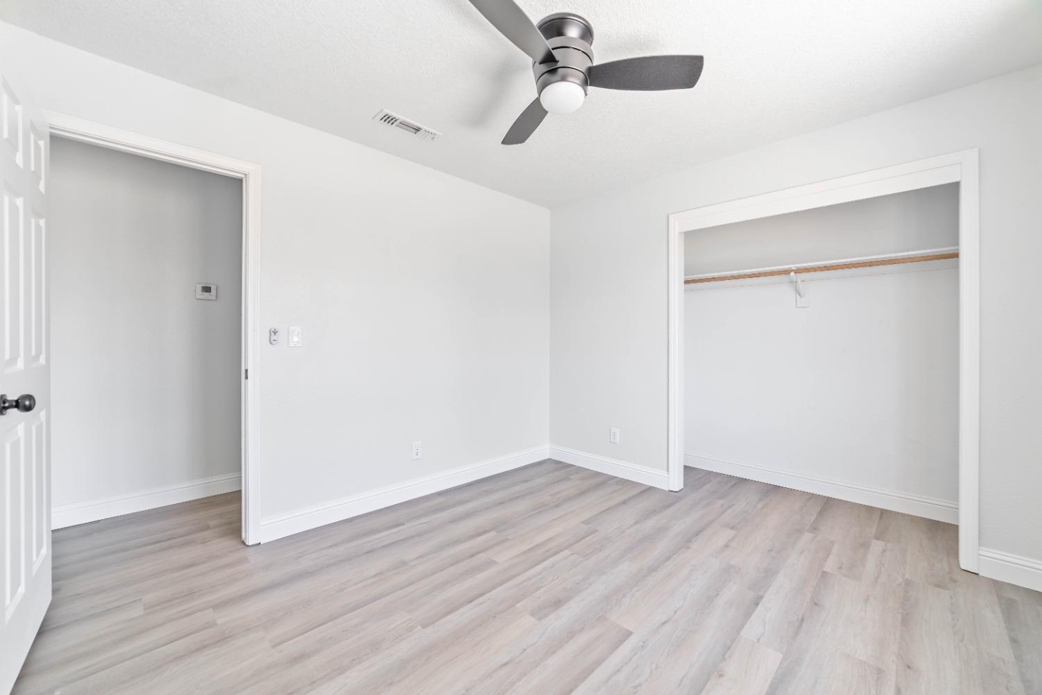 16680 Austin Street Madera, CA 93638 - Photo 14 of 40 an empty room with wooden floor cabinet and closet