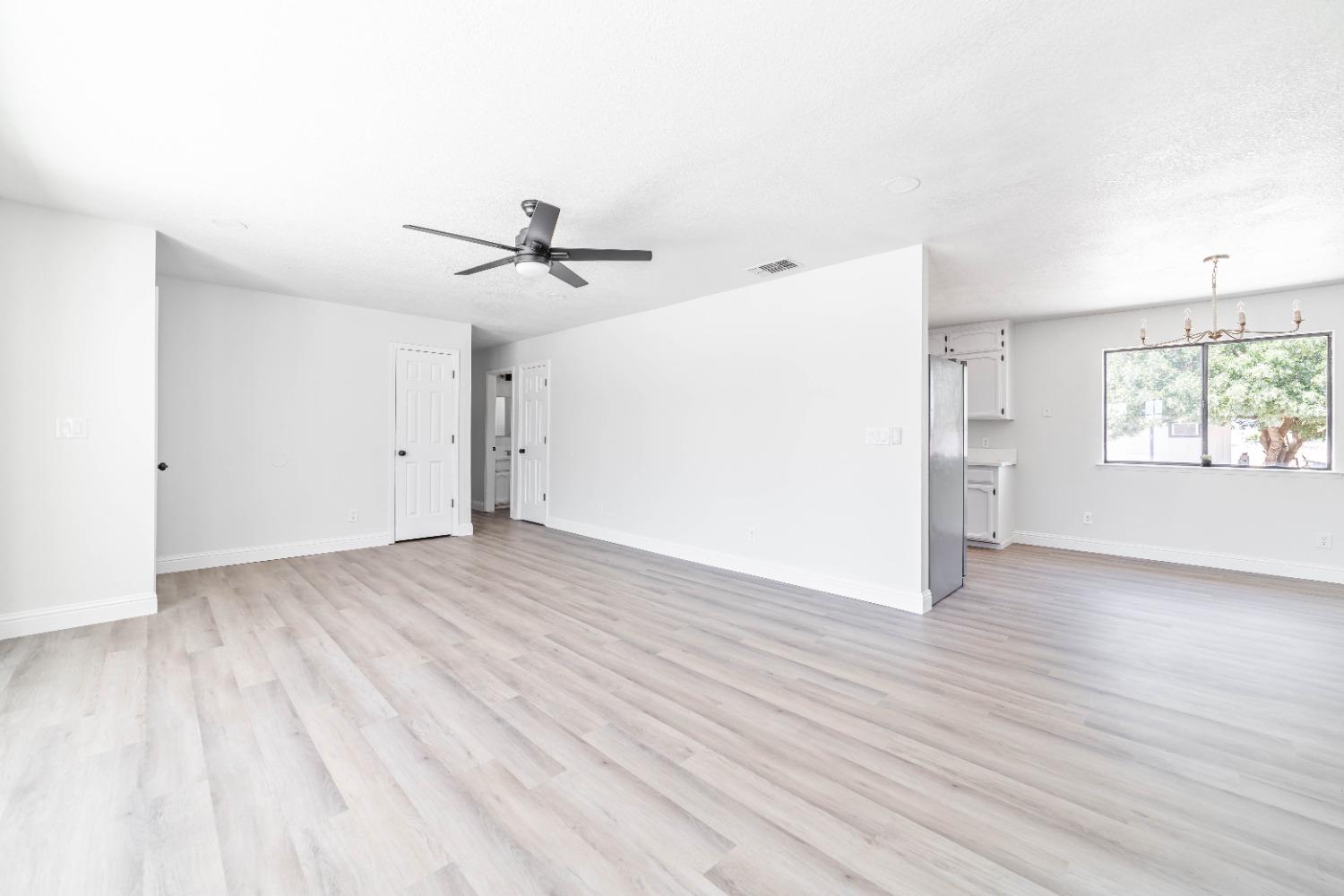 16680 Austin Street Madera, CA 93638 - Photo 3 of 40 an empty room with wooden floor and windows