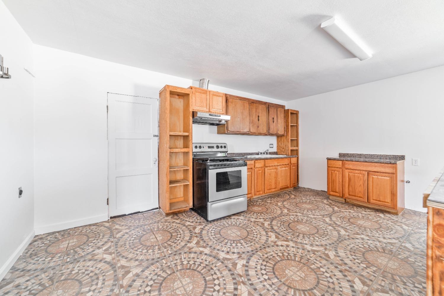 16680 Austin Street Madera, CA 93638 - Photo 34 of 40 a kitchen with stainless steel appliances granite countertop a stove a sink and a refrigerator
