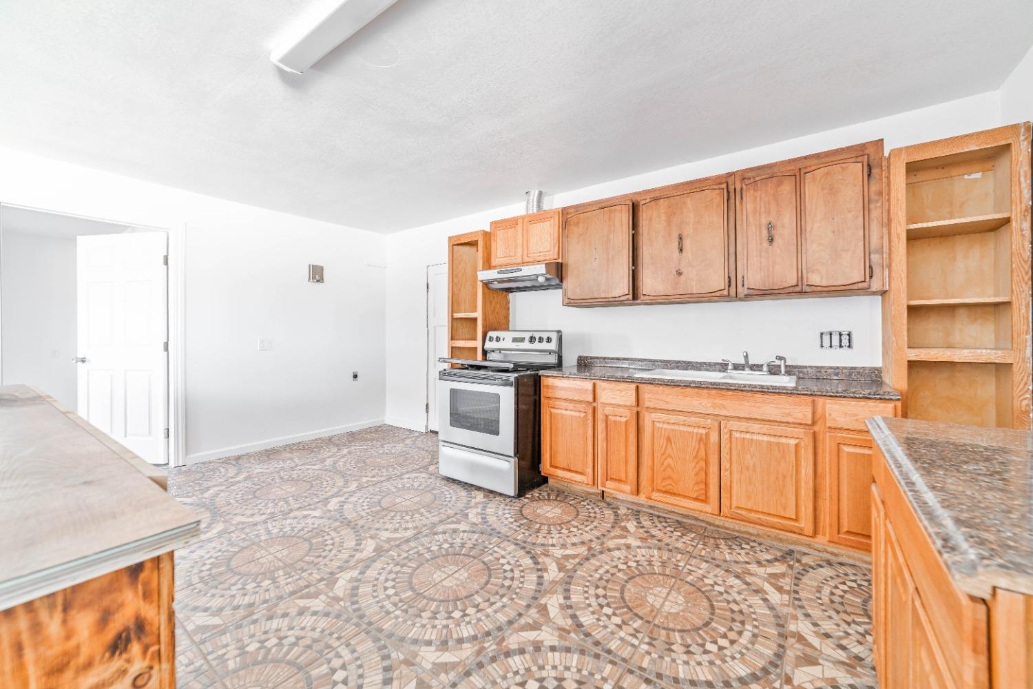 16680 Austin Street Madera, CA 93638 - Photo 35 of 40 a kitchen with stainless steel appliances granite countertop a stove a sink and a refrigerator