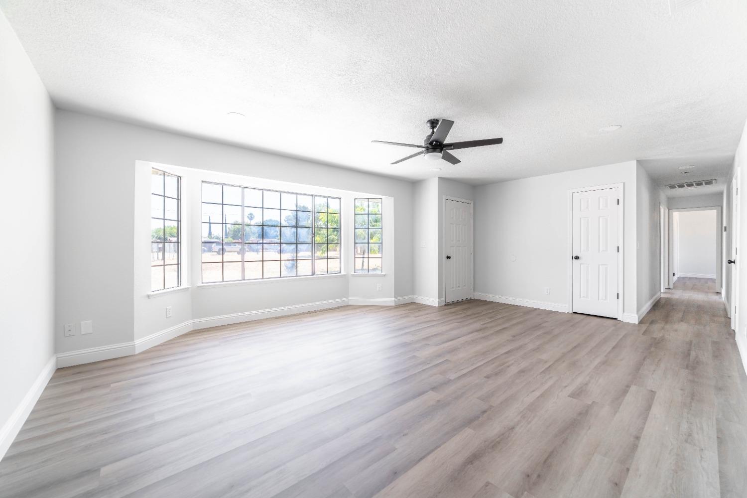 16680 Austin Street Madera, CA 93638 - Photo 5 of 40 a view of an empty room with a window and wooden floor