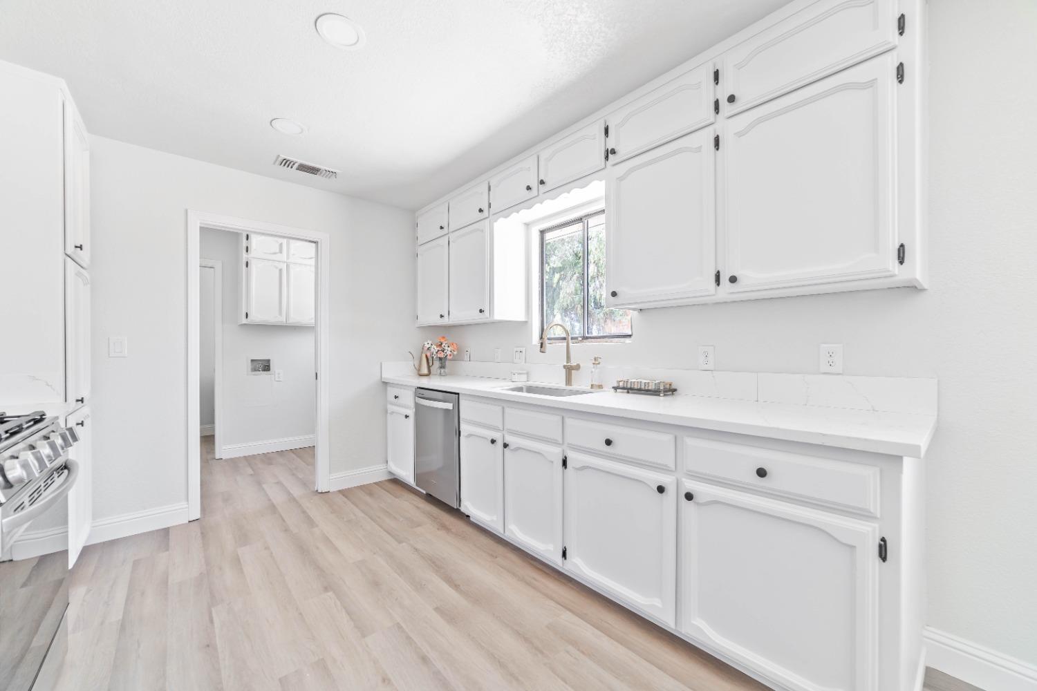 16680 Austin Street Madera, CA 93638 - Photo 8 of 40 a kitchen with granite countertop white cabinets and white appliances