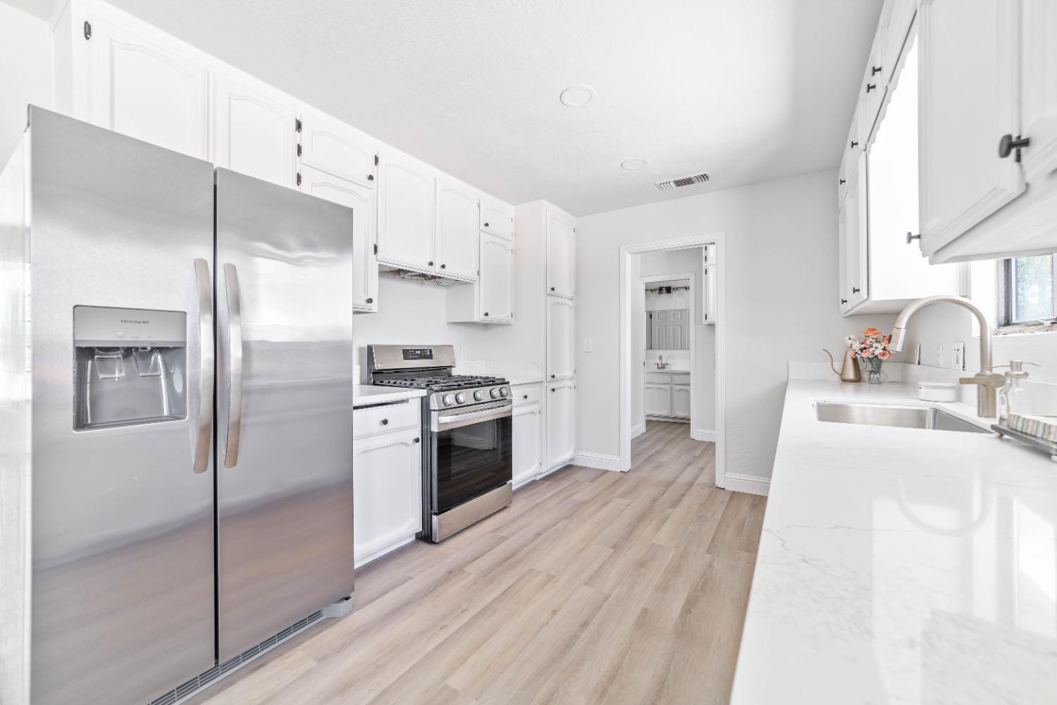16680 Austin Street Madera, CA 93638 - Photo 9 of 40 a kitchen with granite countertop a refrigerator stove and sink