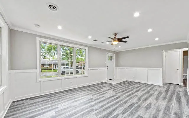 a view of an empty room with a window and wooden floor