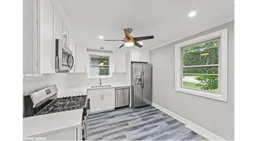 a kitchen with stainless steel appliances granite countertop a stove a refrigerator and a sink with wooden cabinets