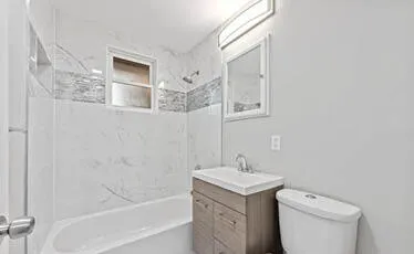 a bathroom with a sink a toilet and shower