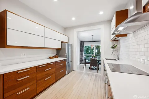 a kitchen with granite countertop a stove a sink and a refrigerator