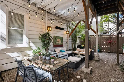 a living room with patio furniture and a potted plant