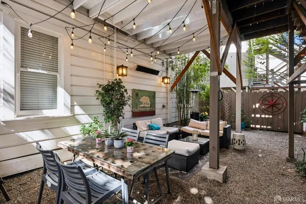 a living room with patio furniture and a potted plant