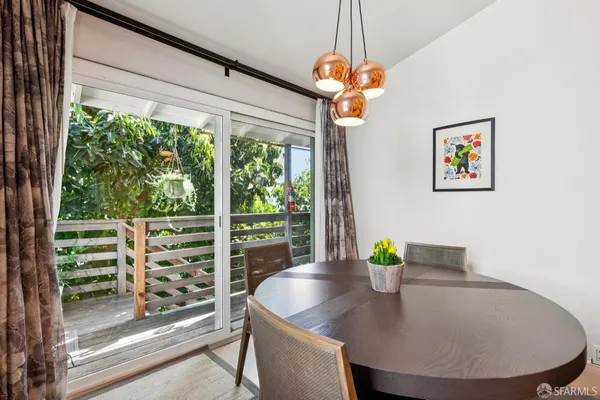 a view of a dining room with furniture a chandelier and windows