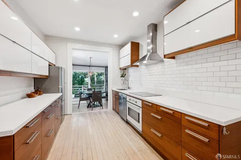 a kitchen with stainless steel appliances granite countertop a sink a stove and a wooden floors