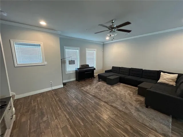 a living room with furniture and a ceiling fan