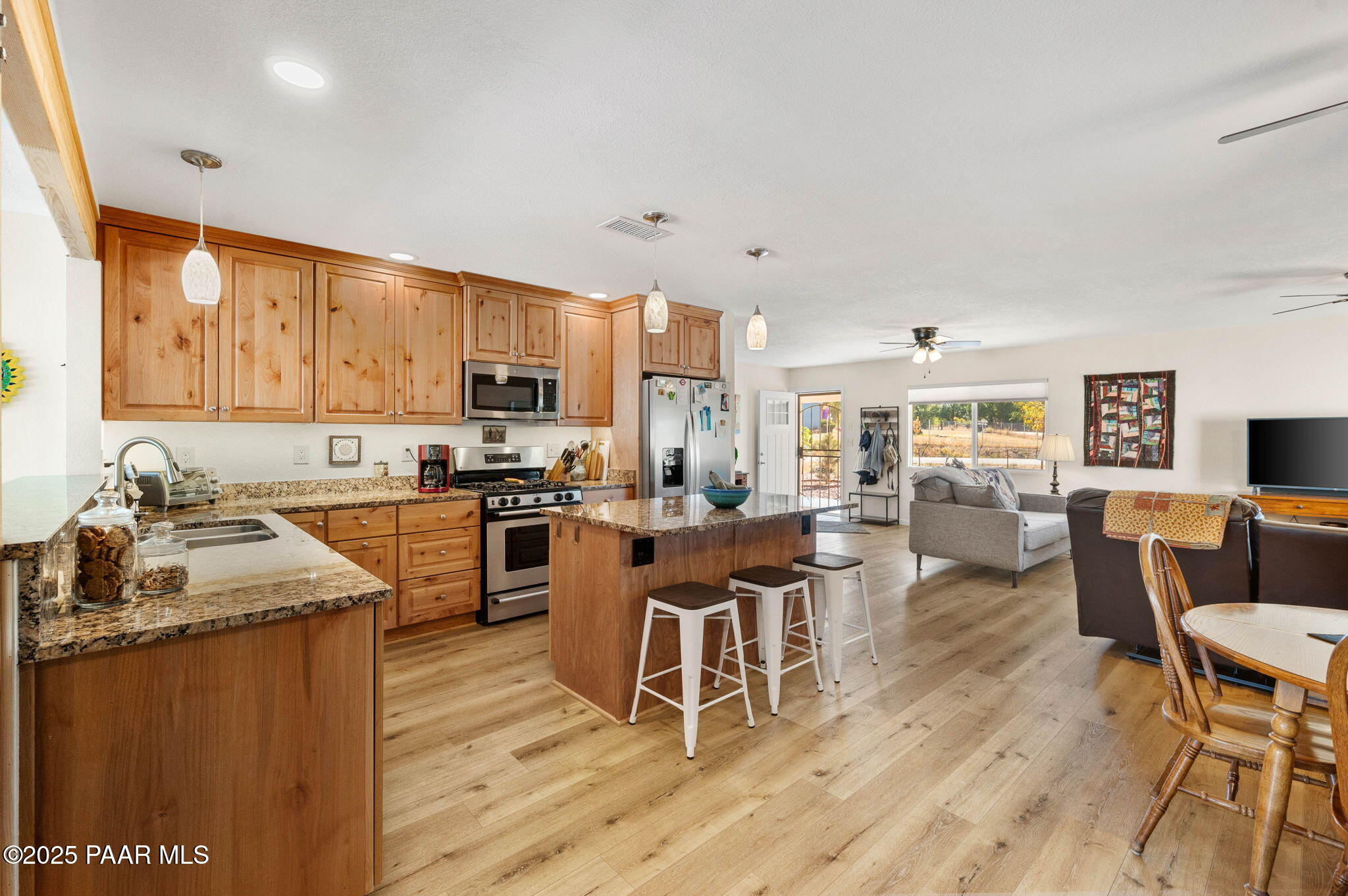 1326 East Ben Road Chino Valley, AZ 86323 - Photo 13 of 51 a kitchen with stainless steel appliances granite countertop wooden floors a stove top oven a dining table and chairs