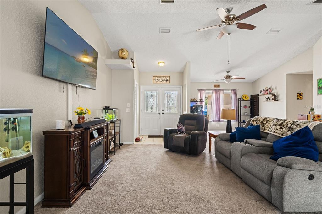 12292 Ronald Street Spring Hill, FL 34609 - Photo 3 of 18 a living room with furniture a flat screen tv and a chandelier
