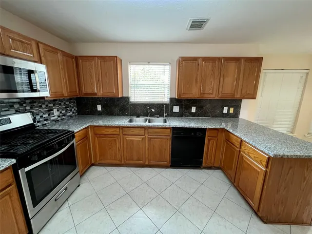 a kitchen with a sink stove top oven and cabinets