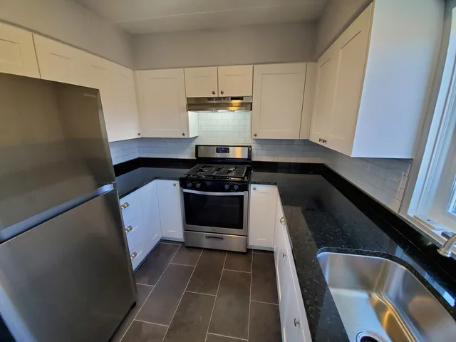 a kitchen with a sink and white cabinets
