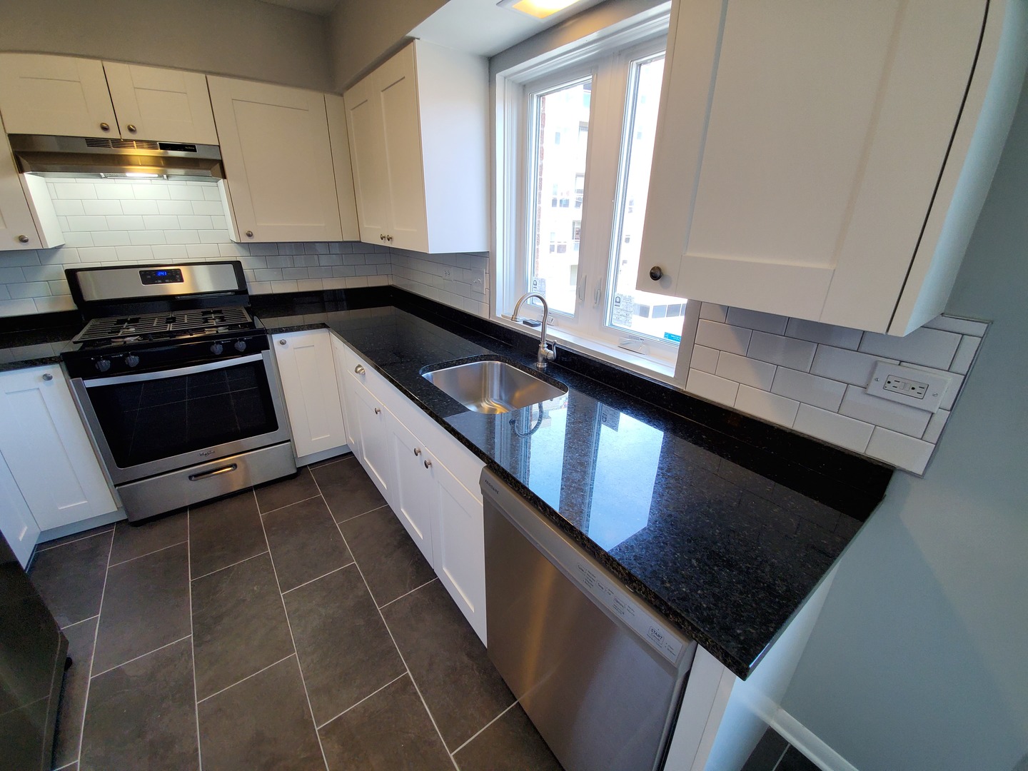 659 South River Road, Unit 5C Des Plaines, IL 60016 - Photo 13 of 24 a kitchen with granite countertop stainless steel appliances a stove a sink and a microwave