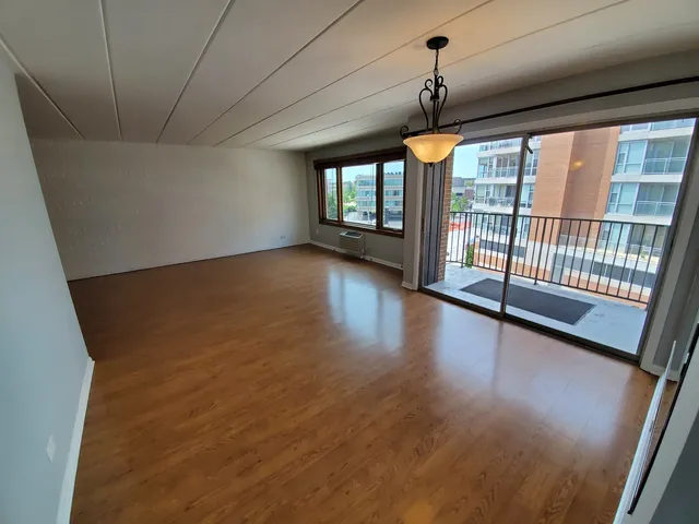 a view of a room with wooden floor and windows