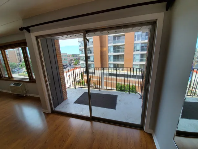 a view of a porch with wooden floor and a floor to ceiling window