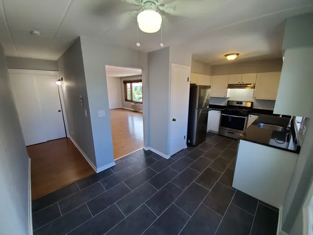 an open kitchen with refrigerator and microwave