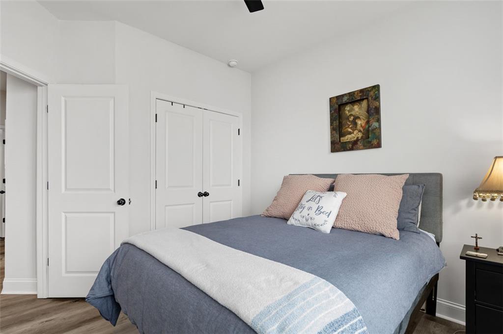 6176 Eves Way Norcross, GA 30071 - Photo 16 of 36 a bedroom with a bed and wooden floor