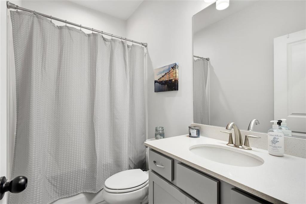 6176 Eves Way Norcross, GA 30071 - Photo 18 of 36 a bathroom with a sink a toilet and shower curtain