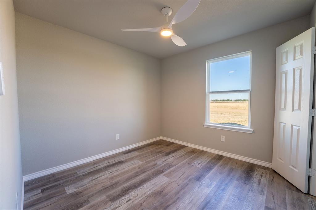 1032 Springview Lane Mabank, TX 75147 - Photo 8 of 15 an empty room with wooden floor and windows
