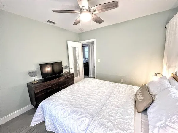 a bedroom with a large bed and a chandelier