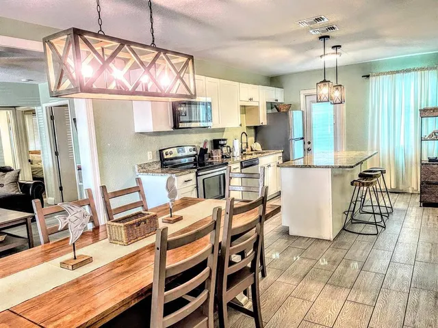 a kitchen with stainless steel appliances granite countertop a sink a stove and a refrigerator