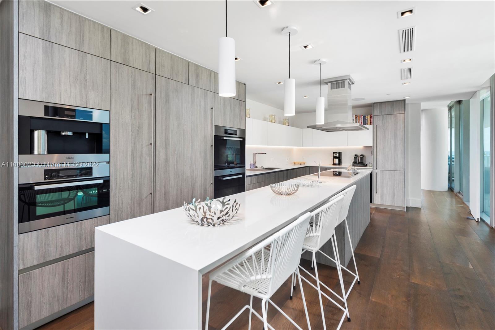 360 Ocean Drive, Unit 501S Key Biscayne, FL 33149 - Photo 11 of 40 a kitchen with kitchen island wooden cabinets and stainless steel appliances