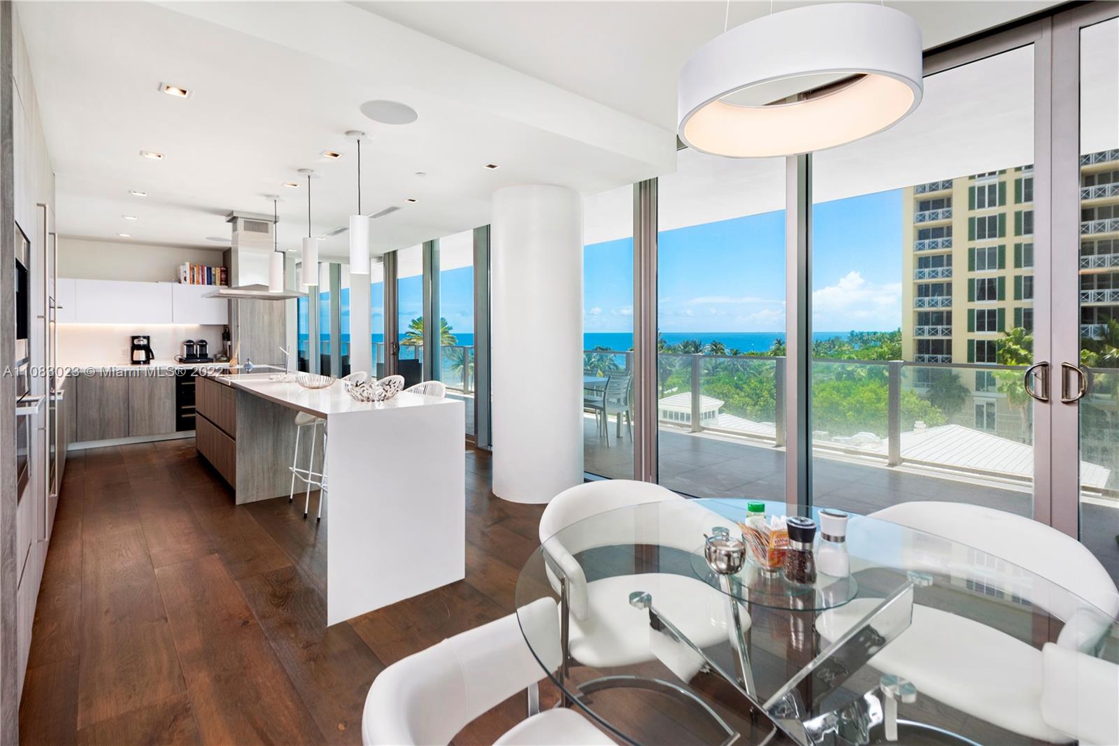 360 Ocean Drive, Unit 501S Key Biscayne, FL 33149 - Photo 13 of 40 a view of a dining room with furniture a chandelier and wooden floor