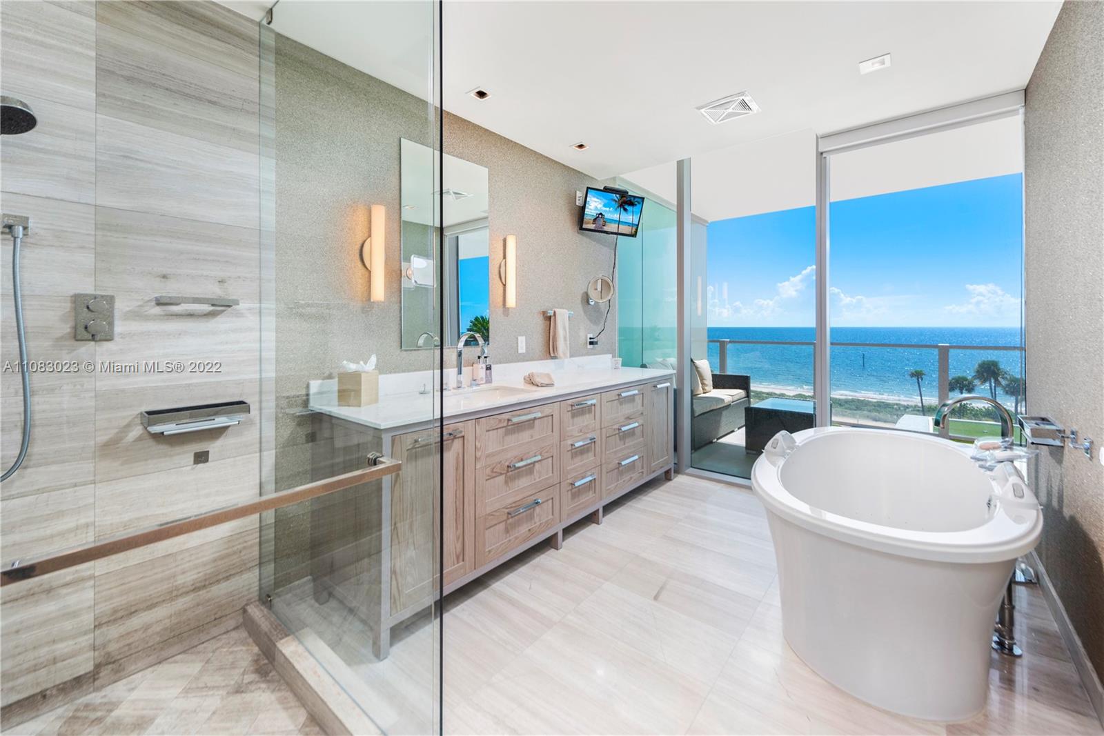 360 Ocean Drive, Unit 501S Key Biscayne, FL 33149 - Photo 19 of 40 a bathroom with a double vanity sink a toilet a mirror and bathtub