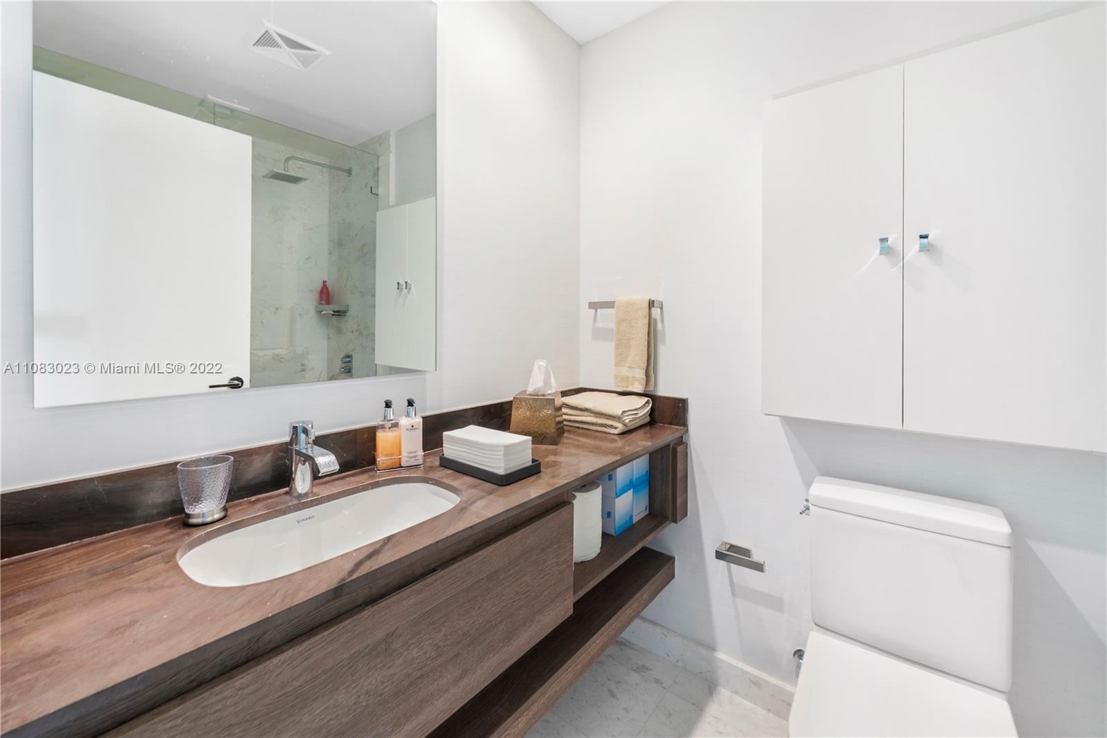 360 Ocean Drive, Unit 501S Key Biscayne, FL 33149 - Photo 23 of 40 a bathroom with a granite countertop sink and a mirror