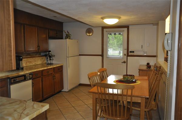 26 Mansfield Drive Wakefield, MA 01880 - Photo 17 of 26 a kitchen with stainless steel appliances granite countertop a refrigerator a stove a sink dishwasher with a dining table and chairs