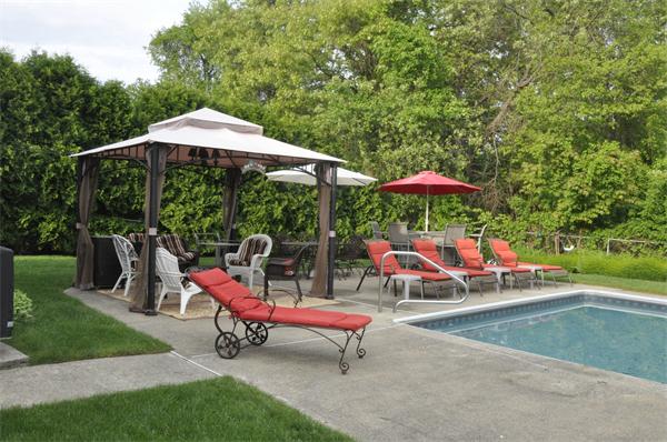 26 Mansfield Drive Wakefield, MA 01880 - Photo 22 of 26 a backyard with table and chairs under an umbrella