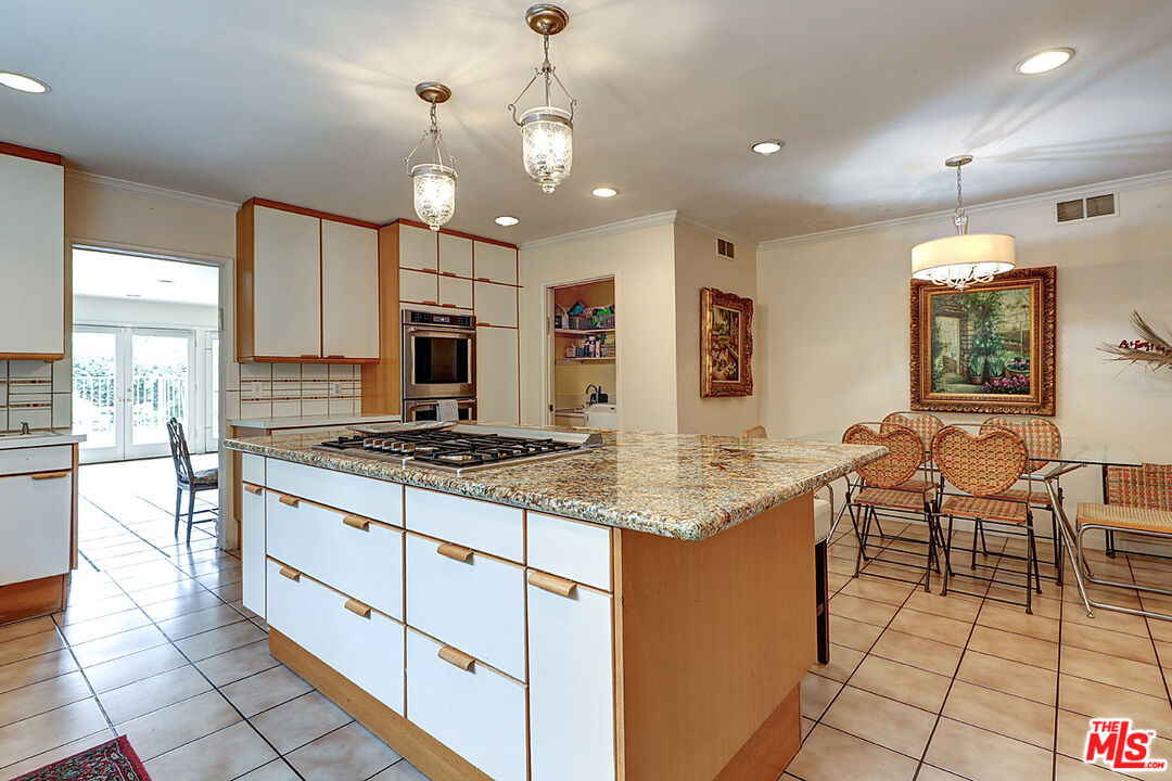 322 North June Street Los Angeles, CA 90004 - Photo 16 of 36 a kitchen with stainless steel appliances granite countertop a stove top oven a sink dishwasher a dining table and chairs with wooden floor